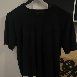 Svart stickad t-shirt från Gina Tricot - En svart stickad t-shirt från Gina Tricot med rund halsringning och korta ärmar. Storlek L men passar även S & M. Enkel och stilren modell som passar perfekt till jeans eller kjol. Mjuk och skön kvalitet.