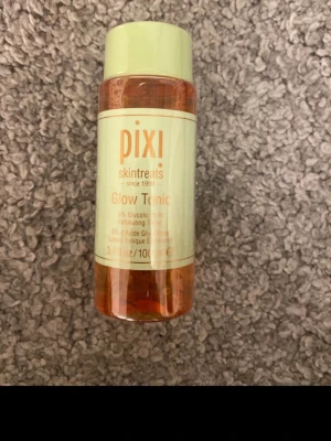 Pixi Glow Tonic 100ml toner - Pixi Glow Tonic är en exfolierande toner med 5% glykolsyra. Kommer i en genomskinlig plastflaska med mintgrönt lock och etikett. Perfekt för att fräscha upp huden och ge glow. Innehåller 100 ml.