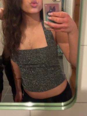 Glittrig topp - Säljer denna snygga glittriga toppen från Nelly, i storlek S. Jag har bara använt den 1 gång så den är som ny. Säljer då jag köpte den för ett tillfälle. Ny pris 300kr!