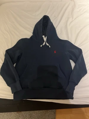 Mörkblå Ralph lauren hoodie - Säljer nu denna feta Ralph lauren hoodie då den blivit för liten. Den har inga skador eller liknande och är som i nyskick. Skulle nog säga att denna S hoodie passar folk som är runt 165-170 cm långa. Hör av dig vid minsta fundering. Priset ej hugget i sten!