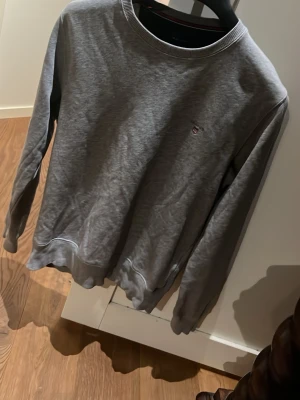 Grå sweatshirt från Gant - Klassisk grå sweatshirt från Gant med rund halsringning och diskret logga broderad på bröstet. Tröjan är köpt för över 700kr och är fortfarande i mycket bra skick