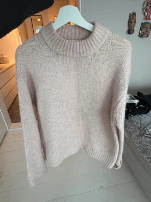 Beige stickad tröja  - Mysig beige/ljusrosa oversized tröja från H&M i storlek XS.  Perfekt för kyliga dagar och enkel att styla med jeans eller kjol. Materialet är mjukt och ger en avslappnad vibe.