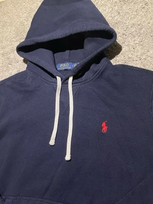 Polo Ralph lauren hoodie - Hoodie Polo Ralph Lauren 🧥  Navy blue Polo Ralph Lauren hoodie with a red logo. Appears in excellent condition with no visible flaws.  ⭐️ Condition: 9/10 🎲 Size: M 🎨 Color: Navy Blue 📦 Fast and careful shipping.