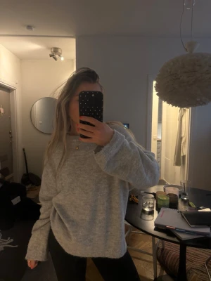 Ljusgrå stickad tröja i oversized modell - Supermjuk och oversized ljusgrå stickad tröja med rund hals och långa ärmar. Perfekt att mysa i under kyliga dagar och enkel att matcha med jeans eller leggings. Stilren och enkel design som funkar till det mesta.