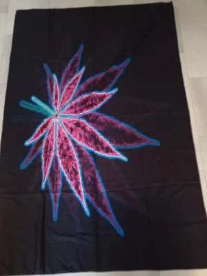 Väggbonad med neonfärgat bladmotiv - Väggbonad med stort neonfärgat bladmotiv i rosa, blått och grönt. Bonaden har en unik och färgstark design som verkligen sticker ut. Perfekt för dig som vill ha något annorlunda. 150 x 100 cm.