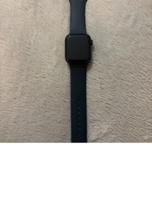 Apple Watch - Snygg Apple Watch med svart armband. Skärmen ser ut att vara i gott skick utan synliga repor eller skador. Perfekt för dig som vill ha koll på hälsa, notiser och träning direkt på handleden.pris kan även diskuteras!!