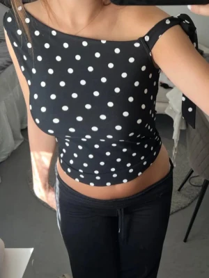Prickig topp  - En jättesöt svart topp me vita prickar i S från New Yorker som man knyter på ena axeln💋köpt på Plick och bilden är förra säljarens men fixar absolut egna om det önskas! 