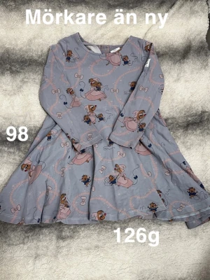 Ljusblå klänning med musmönster - Supersöt ljusblå klänning med lång ärm och snurrig kjol. Klänningen har ett gulligt mönster med små möss och rosetter i rosa och blått. Perfekt för dig som gillar lekfulla prints och mjuka material.🌸 Mörkare än ny. Storlek 98. Polarn o pyret Disney kollektion 