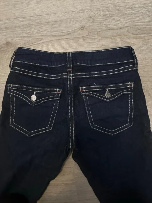 Mörkblå jeans från Gina Tricot - Mörkblå jeans från Gina Tricot med några små röda detaljer. Har användts en gång.
