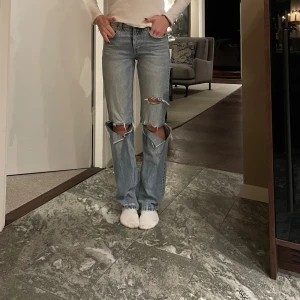 Ljusa ripped jeans från Zara - Säljer ett par ljusblå jeans från Zara. Mid waist. Jag är 166 cm.