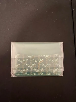 Grön g plånbok  - Säljer en grön plånbok  med deras ikoniska grafiska mönster i vitt och beige. Insidan är orange och plånboken har flera fack för kort. Perfekt för dig som vill ha något stilrent och unikt i fickan.