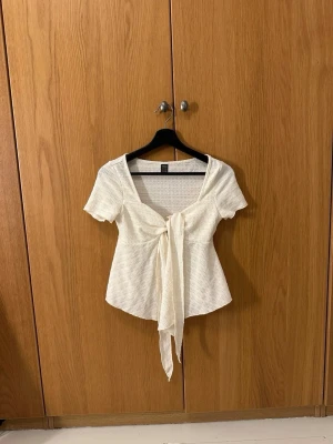 Vit knytblus. - Supersöt vit blus från SHEIN i storlek S med korta ärmar och en stor knytning framtill. Bara att skriva vid funderingar☺️