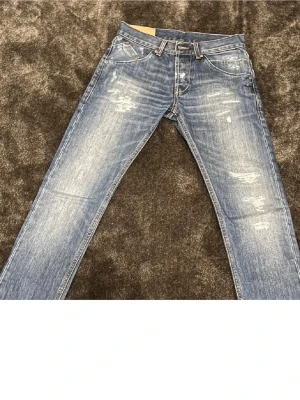 Blå jeans från Chironoc, storlek 29 - Säljer ett par blå jeans från Chironoc i storlek 29. De har slitna detaljer och snygg tvätt med ljusa partier. Klassisk femficksmodell med nitar och kontrastsömmar. Passar dig som gillar en cool och avslappnad stil.