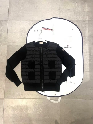 Moncler cardigan  - Hej! Jag säljer nu min jättefina Moncler cardigan. Cardiganen är i jättebra skick och har inga defekter eller liknande skicket 9,5/10. Den är äkta och köpt online. Jag säljer den pågrund av att den inte riktigt passar min personliga stil. Moncler dustbag lapprna osv ingår med jackan. Hör av dig vid minsta lilla fråga! 💕