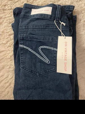 Mörkblå bootcut jeans  - Mörkblå bootcut jeans med vita detaljer på bakfickorna från din vintage shop i nyskick. Säljer eftersom dom inte kommer till alnvändning, skriv för mer detaljer/bilder💕pris kan diskuteras!