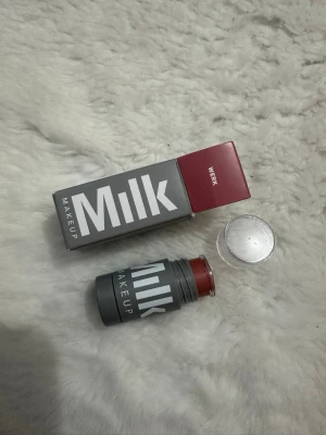 Milk Makeup rouge stick 'Werk' - Rouge stick från Milk Makeup i färgen 'Werk', en varm rosabrun nyans. Kommer i en smidig grå plastförpackning med vit logga och genomskinligt lock. Perfekt för att ge kinderna en fräsch och naturlig färg.