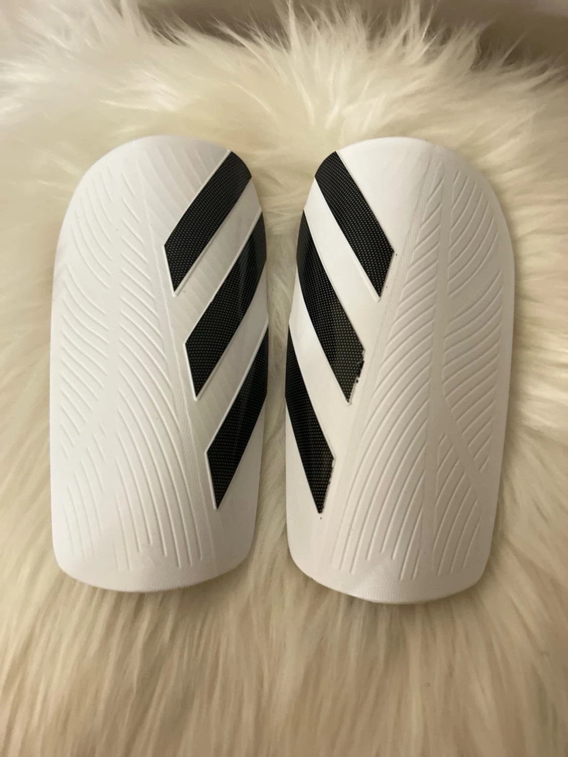 Vita Adidas benskydd med svarta ränder storlek M