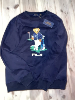 Raulph lauren tröja - Snygg mörkblå tröja från Polo Ralph Lauren  och den ikoniska björnen såklart, splitter ny försökte ta på mig den men den var nästan för stor