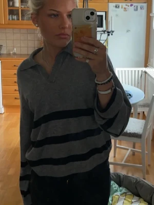 Stickad tröja från Object - Säljer en grå stickad tröja från Object med svarta horisontella ränder. Tröjan har krage och v-ringning. Storlek xs, 100kr 