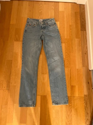 Ljusblå raka jeans från 157 storlek XXS - Säljer ett par ljusblå jeans från 157 i storlek XXS. Modellen har raka ben, klassisk femficksdesign och knäppning med fyra silverfärgade knappar. Jeansen har en normal passform och är tillverkade i jeansmaterial med snygga kontrastsömmar.