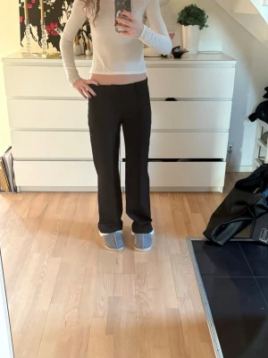 Svarta kostymbyxor med rak passform - Säljer ett par svarta kostymbyxor med rak och lite loose passform. Dem är ifrån madlady i storlek 34 men skulle passa 36och längden regular. Byxorna har medelhög midja och klassiska pressveck framtill. Materialet känns som en mjuk och lite tjockare polyesterblandning. 