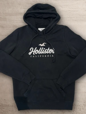 Hollister hoodie S - En snygg hoodie från hollister i färgen svart och ett vitt tryck. Storlek S skulle jag säga men står L. Bra skick 9/10. 😀