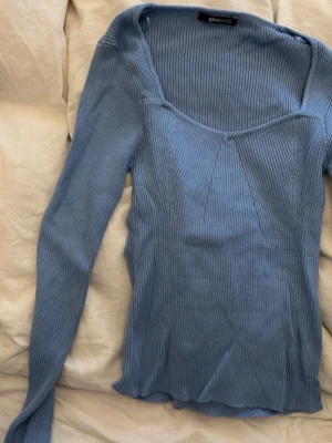 blå topp från gina tricot - Blå ribbad topp från gina tricot med slits vid ärmarna. I storlek xs
