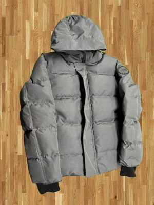 Grå pufferjacka från Canada Goose - Varm vinterjacka, perfekt för kallt klimat. Snygg grå färg, i mycket gott skick. Dragkedjor och muddar i bra skick. Storlek L – normal passform. Snabb frakt 📦 Öppen för seriösa bud.