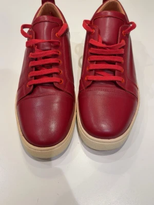 Christian Louboutin skor 44 - Snygga röda sneakers från Christian Louboutin i storlek 44. Använda max 5-10 gånger så de är i ganska fint skick