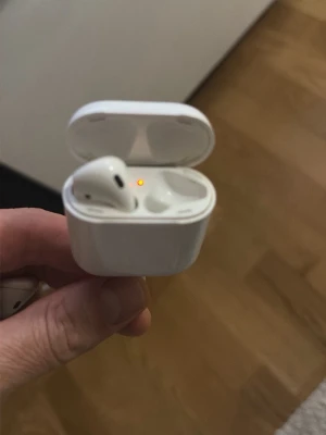 AirPods 2 - Säljer ett par Apple AirPods 2 med laddningsetui. Fungerar utmärkt och laddar som de ska, synlig indikatorlampa. Små tecken på normalt bruk, inga synliga större skador eller repor. Perfekt för trådlös musik och samtal.Höger sidan fattas