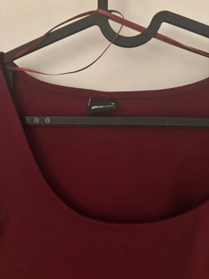 Vinröd långärmad topp Gina Tricot🫶🏻 - Säljer en vinröd långärmad topp från Gina Tricot i mjukt bomullsmaterial. Toppen har en djup rundringning och slits vid ärmsluten för en extra detalj. Enkel och stilren modell som är lätt att matcha🤍