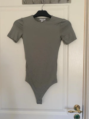 Grön body aldrig använt - När jag köpte denna body så råkade jag köpa två stycken med olika storlekar så jag säljer den med mindre storlek. Från NewYorker strl XXS. Själva bodyn är låg så det blir inte hud som syns mellan byxor och plagget.