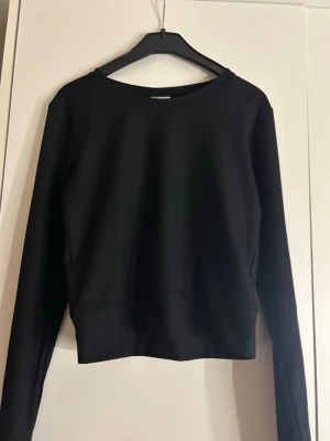 Svart ribbad långärmad topp Kappahl - Säljer en svart långärmad topp från Kappahl i storlek 158/164. Toppen är ribbad och har en enkel, stilren design med rund hals. Perfekt att matcha med jeans eller kjol för en clean look.