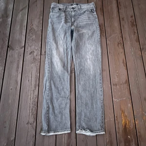 Grå jeans från Replay, raka ben - Säljer ett par grå jeans från Replay med klassisk femficksdesign och raka ben. Jeansen har en snygg tvättad look och normal passform. Perfekta till en avslappnad stil och funkar året runt. Materialet är slitstarkt jeans och färgen är en ljusgrå ton.