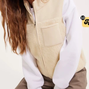 Beige fleeceväst med dragkedja - Västen har en enkel bröstficka och är tillverkad i mjukt teddyfleece-material.💛