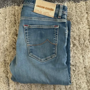 Blå jeans från Jacob Cohën - Snygga blå jeans från Jacob Cohën. Ny pris är ca 7000kr, mitt pris 1549kr! Priset är ej hugget i sten! Modellen är ca 180 cm och jeansen är lite stora fan honom. Hör av dig vid funderingar!