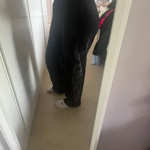 GASP byxor - Säljer ett par svarta GASP byxor med bred passform och stort tryck längs ena benet. Byxorna har resår i midjan. En av sömmarna har börjat gå upp (se bild 3) och det är en liten fläck som inte går bort (se bild 4) annaras är dom i gott skick. Nypriss: 799kr. De är extra långa. 