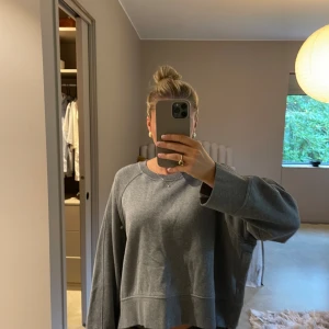 Grå oversized sweatshirt med dragkedja - Mysig grå sweatshirt från Arket i oversized modell. Tröjan har långa ärmar, rund halsringning och en dragkedja på varje sida. Insidan är mjukt fodrad.