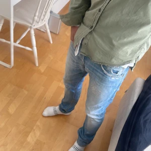 Dondup George med slitningar - Säljer nu dessa sjukt snygga Dondup jeans med slitningar i modellen George🙌 Skicket är perfekt med många snygga detaljer! Storleken är W30 och de har en slim/straight passform🤩 Inga andra jeans är som dessa då slitningarna är gjorda ”custom made” av en textilkonstnär🤝 De är även tailored och gjorde för perfekt passform! Skriv om du har funderingar💬📱
