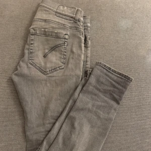 Grå Dondup George jeans - Snygga grå jeans från Dondup George. Jeansen har klassisk femficksdesign, slitna detaljer på benen och är tillverkade i mjukt denimtyg. Perfekta för dig som gillar en smal siluett och en avslappnad look.