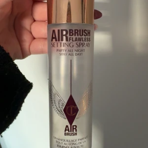 Charlotte Tilbury Airbrush Setting Spray - Tom flaska Airbrush Flawless Setting Spray från Charlotte Tilbury. en snygg genomskinlig flaska med guldlock. Perfekt för en snygg detalj på sminkhyllan som en stilren design med vingdetaljer.