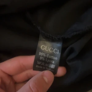 Svart långärmad Gucci t-shirt S - Svart långärmad t-shirt från Gucci i storlek S. Tröjan har ett heltryckt GG-mönster och ribbade muddar vid ärmslut och nederkant. Tillverkad i mjuk bomull med lite stretch för extra komfort. Perfekt för dig som gillar exklusiva streetwear vibes. Priset är inte hugget i sten 