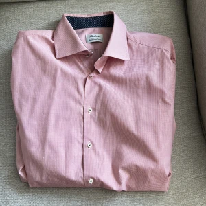 Rutig röd skjorta från Stenströms - Snygg röd skjorta från Stenströms med diskret rutigt mönster och klassisk krage. Skjortan är i bomull och har vita knappar framtill. Perfekt för dig som gillar stilrena och fräscha plagg med en modern touch. OBS ALDRIG ANVÄND!!