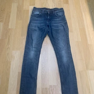 Nudie Jeans - Säljer dessa snygga nudie Jeans till ett bra pris. Storlek 28/32 Slim. Jeansen har ett mycket bra skick med ingen defekt alls. Tvivla inte på att höra av er om frågor!