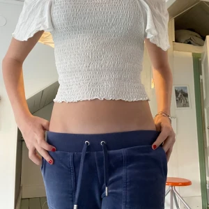 Vit smockad croppad blus - Superfin vit blus med smockad kropp och kort, croppad passform. Toppen har offshoulder-ärmar som är lite volangiga och ger en söt vibe. Perfekt till jeans eller kjol för en fräsch look. Materialet känns lätt och luftigt. Från kappahl i storlek 152. Passar bra och man kan ha volang ärmarna över axlarna eller nedanför