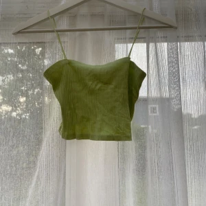 Ljusgrön ribbad linnetopp - Snygg ljusgrön ribbad linnetopp med tunna axelband. Toppen är croppad och har en enkel, fräsch look som passar perfekt till sommaren. Materialet är mjukt och stretchigt för en bekväm känsla.
