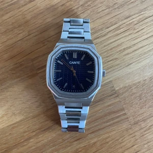 2024 CAINTÉ CLOUDE klocka 41 mm - Stilren klocka från Danska design varumärket CAINTÉ med inspiration från Patek Phillipe Royal Oak med en åttakantig boett och armbandsliknande stil på länkarna. Perfekt för dig som söker en stilren och tidlös klocka med hög kvalité för ett överkomligt pris. Material: högkvalitativt rostfritt stål (316L) Nypris: ca 4100 sek (370 euro)