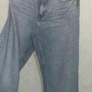 Blå Levi's 501 jeans straight fit - Klassiska ljusblå Levi's 501 jeans med rak passform och normal midja. Jeansen har fem fickor, knappgylf och är tillverkade i robust denim. Perfekta för dig som gillar en tidlös och avslappnad stil.