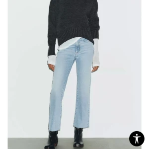 Ljusblå raka jeans med rå kant - Säljer ett par ljusblå jeans med rak passform och croppad längd. Jeansen har rå, fransad kant nertill och klassisk femficksdesign. Perfekta till boots eller sneakers för en chill look.