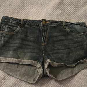 jeansshorts från Denim Co - Snygga blå low waist jeansshorts från Denim Co. med klassisk femficksdesign, uppvikta ben. Modellen har normal passform och low waist / midwaist, Perfekt för hösten med ett par strumpbyxor och en tröha eller till sommaren. Skriv om du är intresserad eller har några frågor! Pris kan diskuteras!🫶🍁